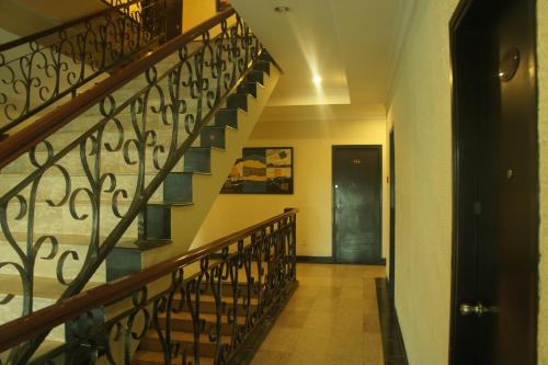 a staircase in a building with wrought iron railing at Sky View Hotel Managed by OS in Batam Center