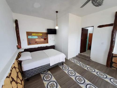 a small bedroom with a bed and a mirror at Casa con alberca frente del mar de Santa clara Yucatan in Santa Clara