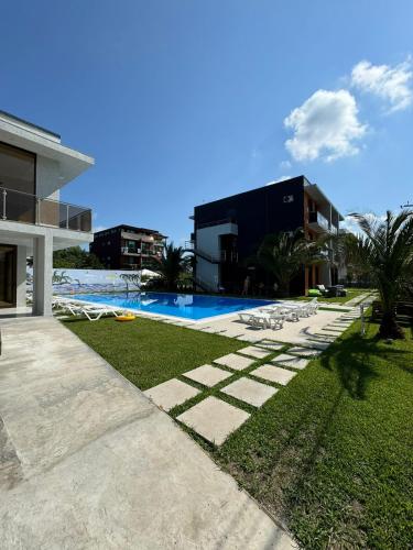 a house with a swimming pool next to a building at Aparthotel Alfa in Ureki