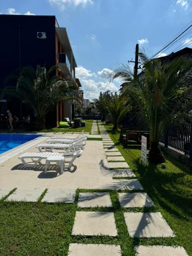 a row of picnic tables next to a swimming pool at Aparthotel Alfa in Ureki