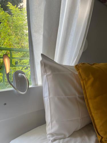 a bed with a pillow next to a window at Kozani elegant. Διαμέρισμα στο κέντρο της κοζάνης in Kozani
