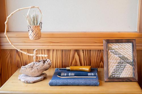 a wooden table with a shelf with a picture and books at Rise's House in Nishio