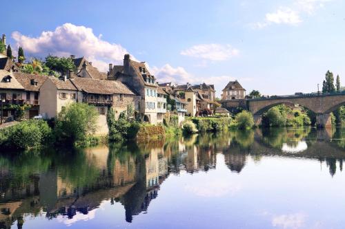 une rivière dans une ville avec des maisons et un pont dans l'établissement Au calme, à Saint-Sylvain