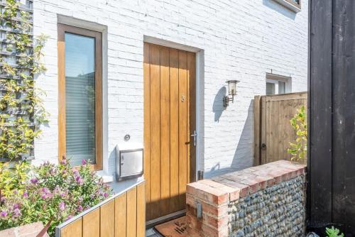 a wooden door of a house with a brick wall at 3 Drayman Square in Southwold
