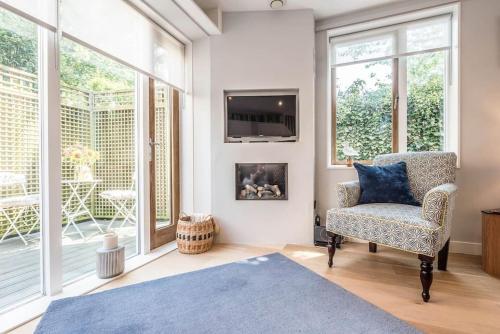a living room with a chair and a tv at 3 Drayman Square in Southwold