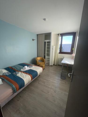 une chambre avec un lit, un bureau et une fenêtre dans l'établissement Appartement 5 chambres proche de toute commodité, à Noisy-le-Grand