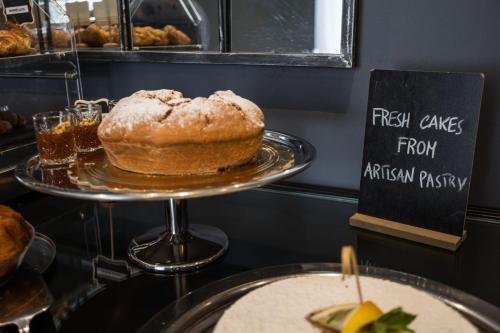 a cake on a plate on a table with a sign at Boutique Hotel Metro 900 in Naples