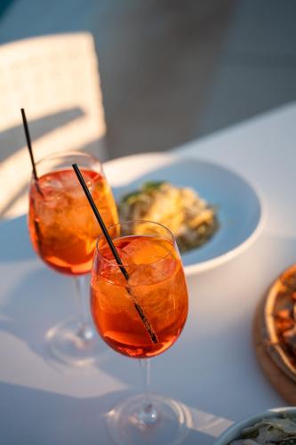 three wine glasses on a table with a plate of food at Niriides Luxury Villas in Methoni