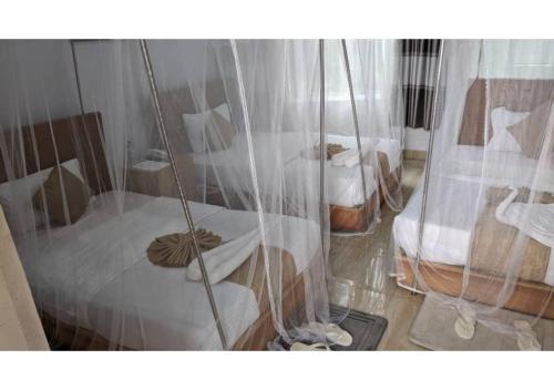 a room with two beds and a swing at Chimpanzee Lodge in Rwumba
