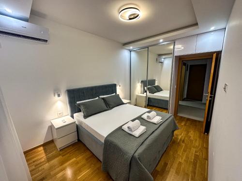 a bedroom with a bed with two towels on it at Enigma Apartment in Ulcinj