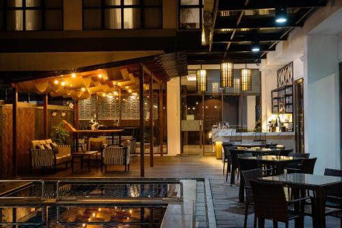a restaurant with tables and chairs and a bar at Laska Hotel Sukabumi in Sukabumi