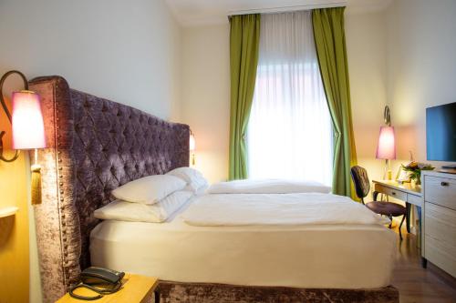 a hotel room with a bed and a window at Classic Hotel Harmonie in Cologne