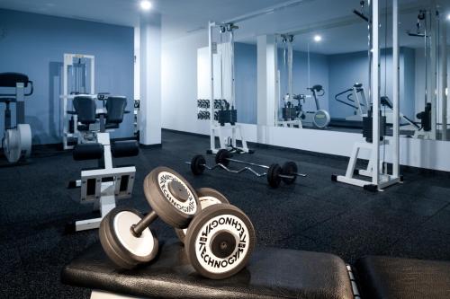 a gym with dumbbells and weights in a room at Hotel Štekl in Hluboká nad Vltavou
