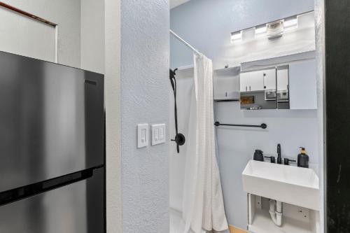 a white bathroom with a sink and a shower at Stylish Studio Suite Near Downtown in Anchorage