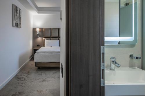 a bedroom with a bed and a tub and a sink at Charm Boutique Hotel in Satu Mare