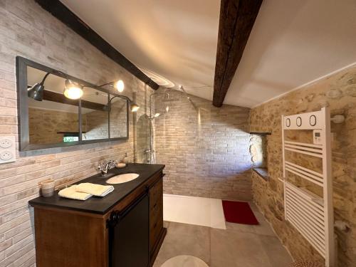 une salle de bain avec un lavabo et un miroir dans l'établissement BERGERIE rénovée avec piscine chauffée et terrain clôturé, à Vallérargues