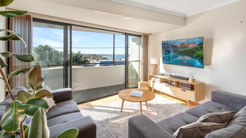 ハスキッソンにあるHusky Oasis - Centre OF Huskisson -のソファとテレビのあるリビングルーム