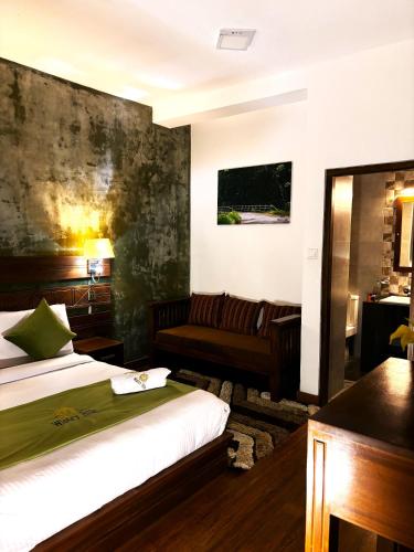 a hotel room with a bed and a couch at Wintry Hills-Nuwara Eliya in Nuwara Eliya
