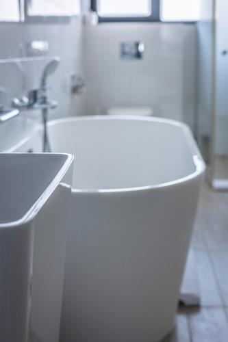 a white bathroom with a sink and a tub at Charm Boutique Hotel in Satu Mare