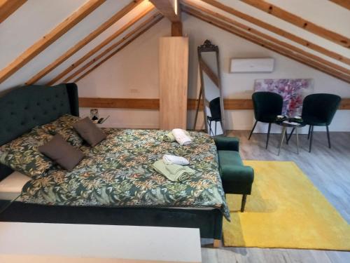 a bedroom with a bed and chairs in a attic at Casa Benessere Istria in Vodnjan