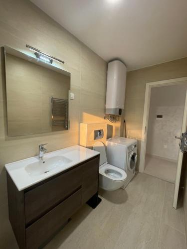 a bathroom with a sink and a toilet and a mirror at Lavander Apartment W Pool and Private Beach in Tivat