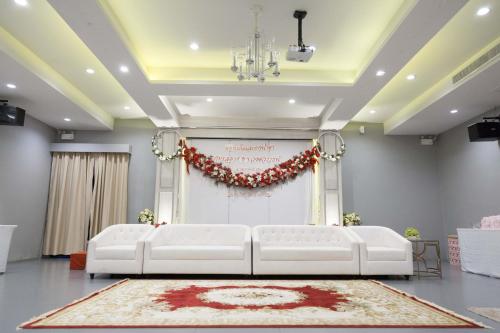 a room with two white couches in front of a stage at Bhukitta Boutique Hotel Phuket Town in Phuket Town