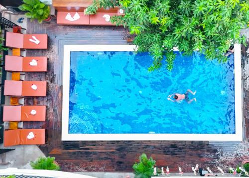 a person swimming in a swimming pool at Bliss & Beats Hostel in Phnom Penh