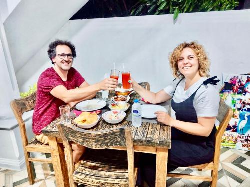 a man and woman sitting at a table with drinks at Mario Family Villa and Restaurant in Negombo