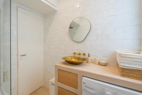 une salle de bain avec un lavabo et un miroir au mur dans l'établissement Urban Retreat in Historic Quarter, à Paris