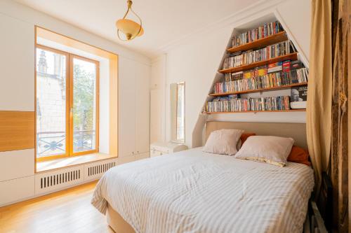 - une chambre avec un lit et une étagère dans l'établissement Urban Retreat in Historic Quarter, à Paris