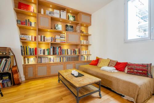 un salon avec un canapé et une étagère dans l'établissement Urban Retreat in Historic Quarter, à Paris