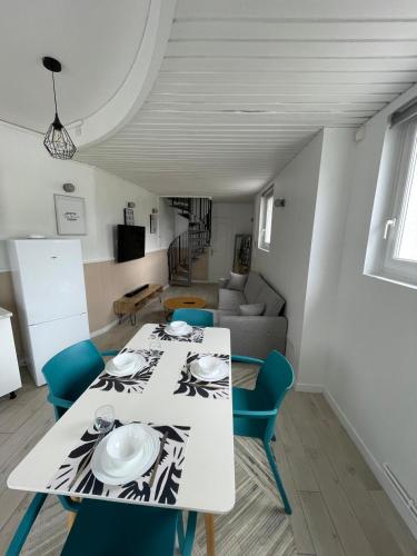 une salle à manger avec une table blanche et des chaises bleues dans l'établissement New Garden Unic 6 personnes, à Amiens