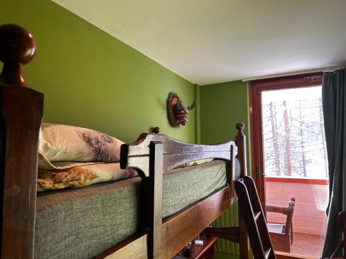 a bed in a room with green walls and a window at Casa Camas, wide 2bedroom, feel the mountain in Breuil-Cervinia