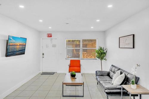a living room with a couch and an orange chair at Hollywood Vacation In Perfect Beach Location Ha01 in Hollywood
