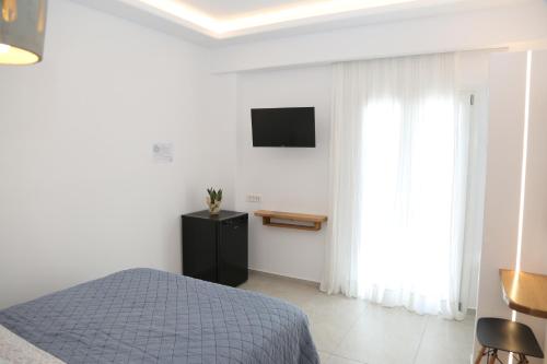 a bedroom with a bed and a television on the wall at Anais in Mýkonos City