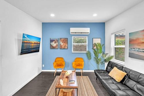 a living room with a black couch and two orange chairs at Hollywood 2 Bdrm Beach Vacation & Hard Rock Sc02 in Hollywood