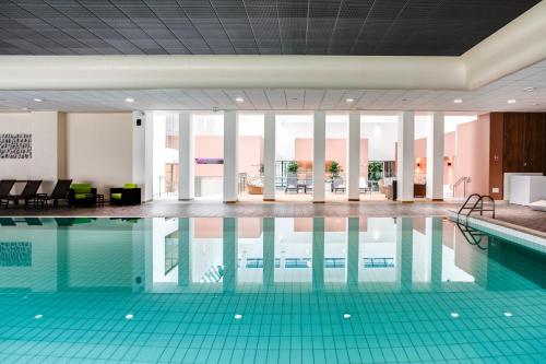 a swimming pool with blue tiles in a building at Hôtel Lyon Métropole in Lyon
