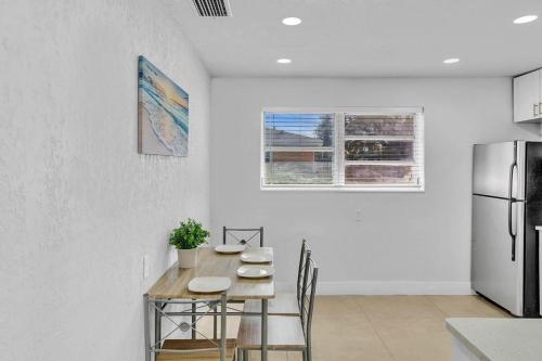 a kitchen with a table and a refrigerator at Modern 2br Near Aventura Mall & Sunny Beach in Hallandale Beach
