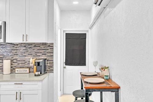 una cocina blanca con una mesa de madera en una habitación en Boutique One Bdrm Close To Aventura Mall & Beach, en Hallandale Beach