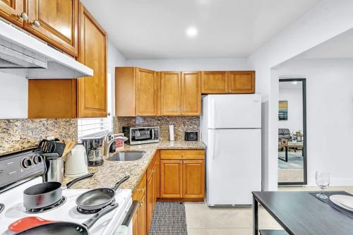 a kitchen with wooden cabinets and a white refrigerator at Hollywood 2 Bdrm New Furnished Beach Vacation Lb2 in Hollywood
