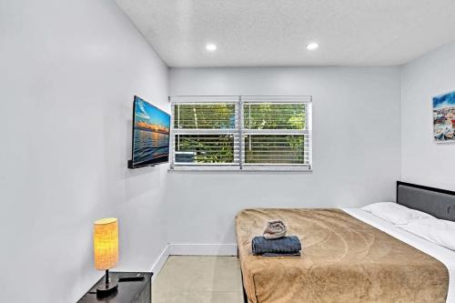 a bedroom with a large bed and two windows at Hollywood 2 Bdrm New Furnished Beach Vacation Lb2 in Hollywood