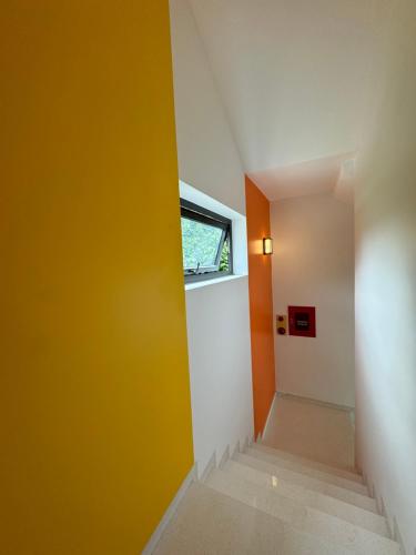 a hallway with a yellow wall and a window at Ha Giang Hostel in Ha Giang