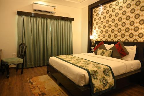 a bedroom with a large bed with a green curtain at The Vaishnavi in Deoghar