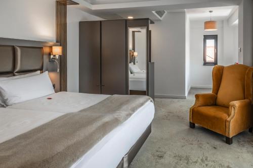 a bedroom with a bed and a chair at Charm Boutique Hotel in Satu Mare