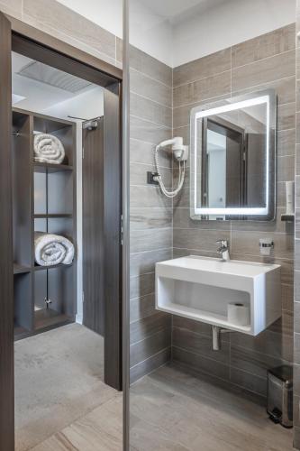 a bathroom with a white sink and a mirror at Charm Boutique Hotel in Satu Mare