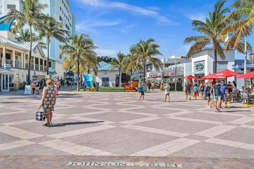 a group of people walking around a square with palm trees at Two Bedroom Hollywood Beach Vacation Sc01 in Hollywood