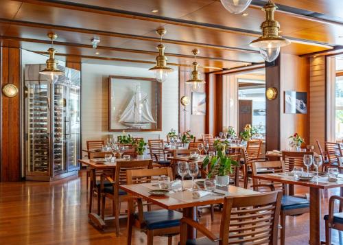 a dining room with wooden tables and chairs at H&ocirc;tel Lyon M&eacute;tropole in Lyon