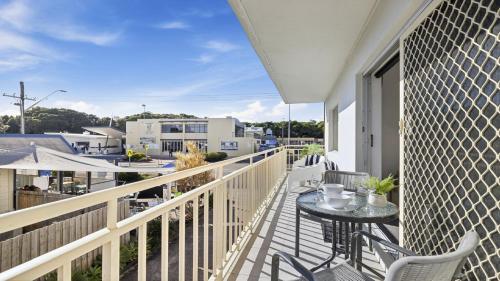 a balcony with a table and chairs on a building at Ocean Echoes Coffs Harbour- Short walk to the beach, Cafes and clubs! in Coffs Harbour