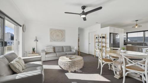 a living room with a couch and a table at Ocean Echoes Coffs Harbour- Short walk to the beach, Cafes and clubs! in Coffs Harbour