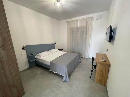 a bedroom with a bed and a table and a television at B&B Casa Giulivo 1 Pantanagianni in Torre Santa Sabina